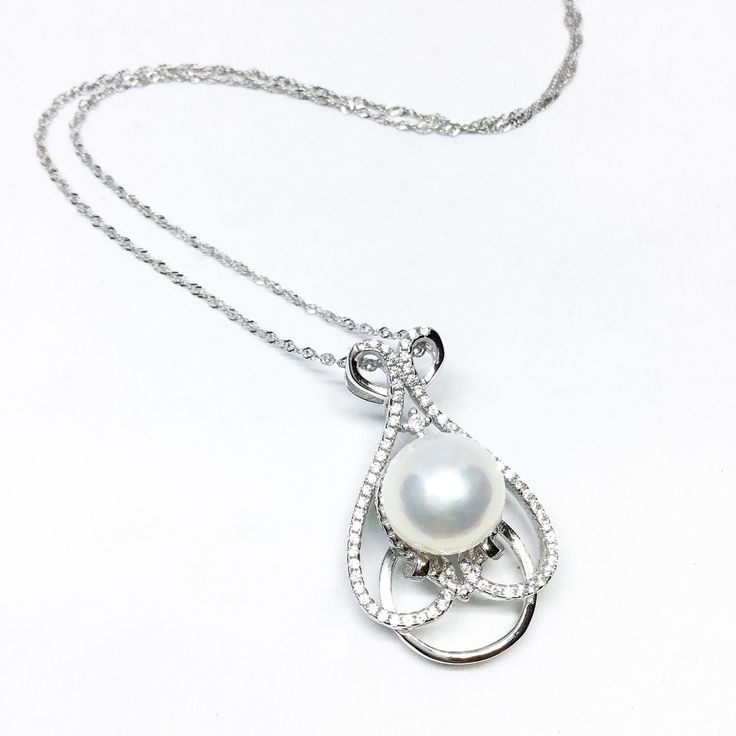 Our Unique Pendant Is Designed With White Freshwater Pearl , Cubic Zirconia And 925 Sterling Silver. You Can Wear It All Day Long. Jewelry : Pearl Pendant Pearl Type : Freshwater Pearl Pearl Grade : AAA+ Pearl Luster : High Pearl Body : Clean Pearl Shape : Button / *Round Pearl Nacre : All (100% nacre)  Necklace Length : 18 Inches = 45.7cm  Pearl Color : White/Pink/Gray/Black Pearl Size: Approx 6-7mm,7-8mm, 8-9mm, 9-10mm, *10-11mm , 11-12mm Clasp : 925 Sterling Silver Metal: Sterling silver Ster Elegant White Diamond Teardrop Pendant Necklace, Elegant White Teardrop Pendant Diamond Necklace, White Teardrop Diamond Necklace Luxury, Dazzling White Teardrop Pendant Jewelry, Classic White Necklace With Pave Setting, Timeless White Necklace With Diamond Accents, Timeless White Gemstone Necklace, Luxury White Teardrop Diamond Necklace, Elegant Sterling Silver Pearl Necklace With Teardrop Pendant