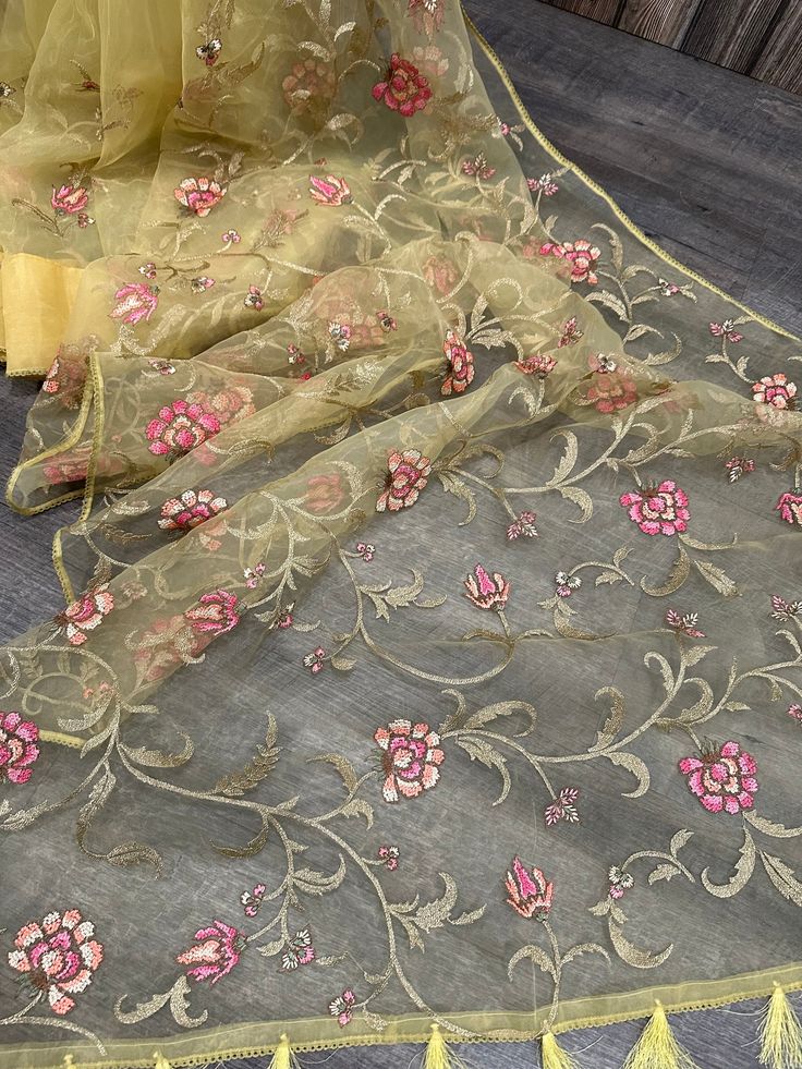 Lightweight and sheer Dhakai Muslin saree with floral resham and zari embroidery . Printed blouse fabric included. Festive Pre-draped Saree With Floral Embroidery In Art Silk, Semi-stitched Art Silk Saree With Floral Embroidery, Multicolor Pre-draped Saree With Floral Embroidery For Festivals, Bollywood Style Embroidered Chanderi Pre-draped Saree, Transitional Embroidered Organza Pre-draped Saree, Festive Multicolor Embroidered Chanderi Pre-draped Saree, Tissue Silk Pre-draped Saree With Floral Embroidery For Festivals, Embroidered Tissue Silk Pre-draped Saree For Celebration, Embroidered Silk Saree For Celebration