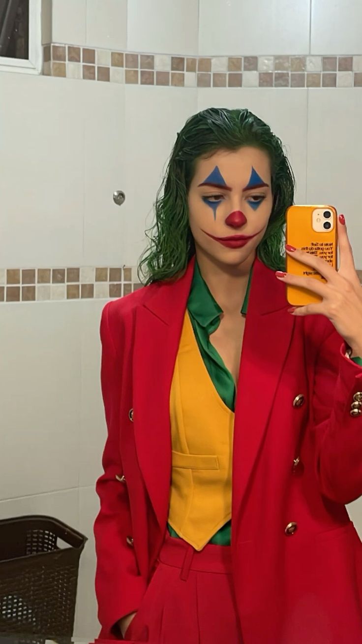 a woman with green hair and clown makeup taking a selfie