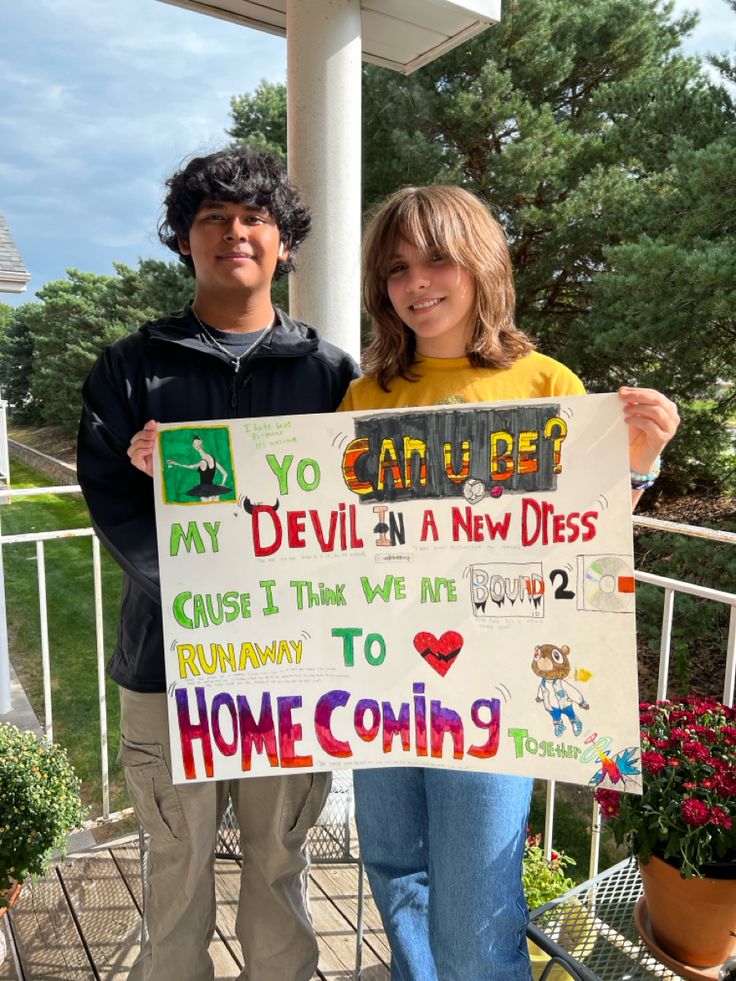 two people holding up a sign that says you can be my devil in a new dress