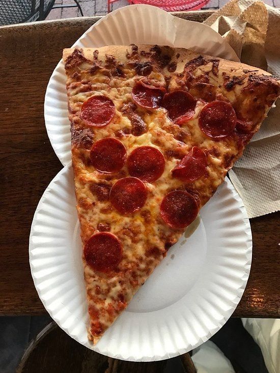 a slice of pepperoni pizza on a paper plate