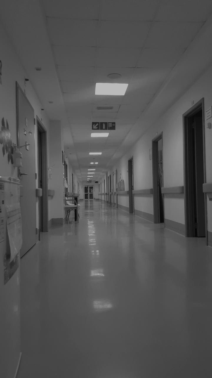 an empty hospital hallway in black and white with no people on the floor or doors