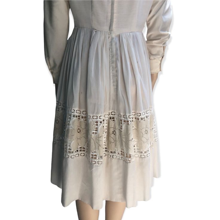 "Here I have a lovely cream dress made by Lou Ross of California in the 1950s.  It features a fine semi transparent pleated skirt with a panel of lace roses around the mid skirt.  Some of the lace has come away in the back please see photos priced accordingly.  This dress has long sleeves which may have been added by the previous owner.  Metal zipper in great working condition. Diamond lace panel around the neckline. One small mark on the back, all in all this is a really sweet dress.  No sizing Beige Lace Trim Midi Dress For Garden Party, Beige Midi Dress With Lace Trim For Garden Party, Knee-length Cream Dress With Lace Patchwork, Beige A-line Midi Dress With Lace Trim, Casual Cream Midi Dress, Cream Midi Dress With Lace Trim For Garden Party, Vintage Midi Dress With Lace Patchwork, Spring Vintage Dress With Lace Patchwork For Daywear, Vintage Midi Dress With Lace Trim For Garden Party