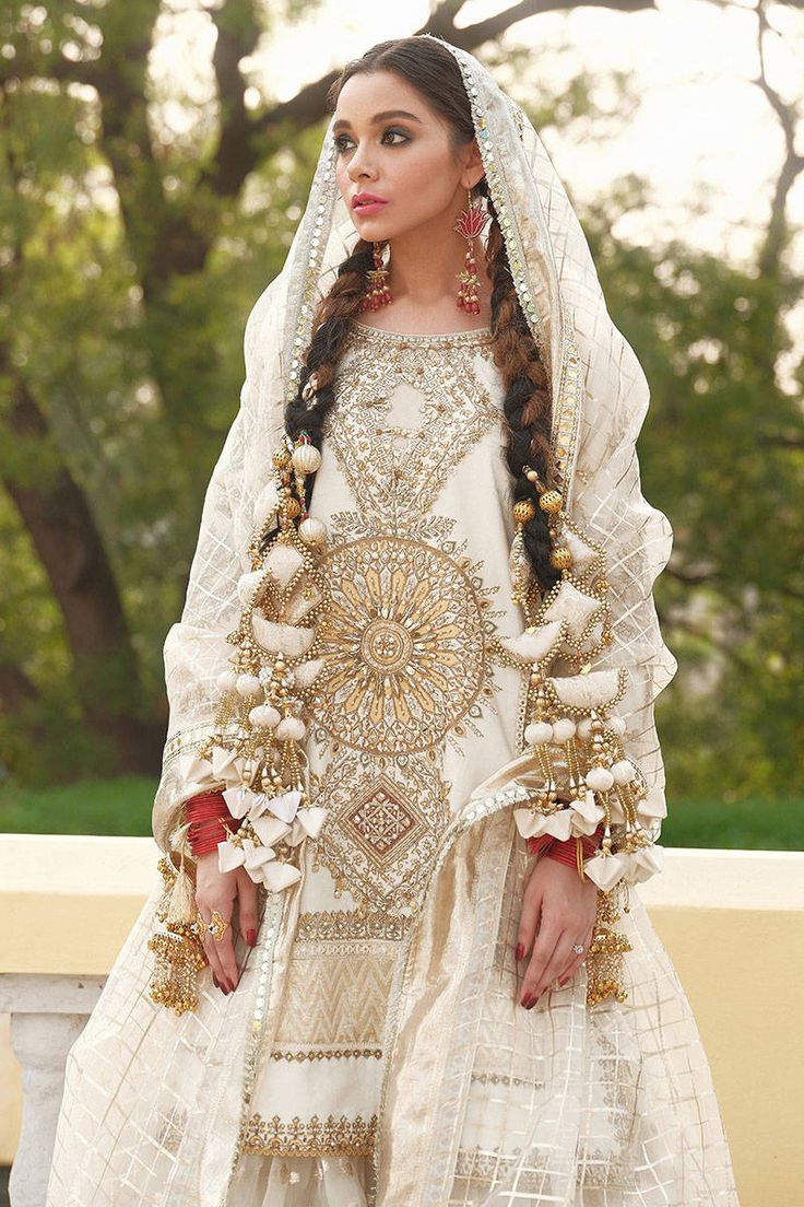 Organza White Sharara Kameez Pakistani Wedding Dresses is a traditional and refined Pakistani Wedding Dress with exquisite adornments on it causing it unpaired in its grace and beauty. The lovely finish of this attire and intricate golden details count more toward the luxuries of this Fancy Sharara Kameez. Organza Kameez: This White Organza Kameez comes in a beautiful kameez in premium quality raw organza. This kameez is decorated with breathtaking embellished patterns accompanied by a tilla. Fu Traditional Wedding Dress For Ceremonies, Traditional White Wedding Dress For Festive Season, Traditional White Wedding Dress With Drape, Traditional White Wedding Dress For Ceremonies, Anarkali Style Traditional Drape Wedding Dress, Anarkali Style Wedding Dress For Traditional Ceremonies, Traditional Festive Wedding Dress, Unstitched Gold Embroidered Sharara For Wedding, Unstitched Wedding Sharara With Gold Embroidery