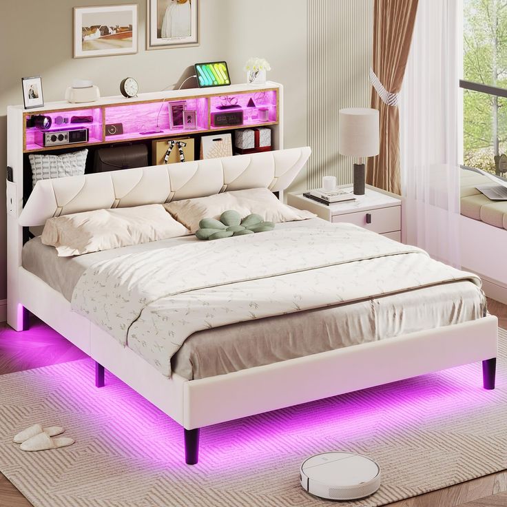 a white bed with purple lights on the headboard and foot board in front of it