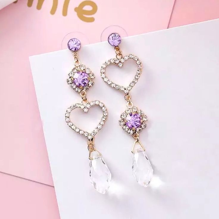 These Asymmetrical Gold Tone Drop Earrings Feature Clear Crystal Heart Outlines With Purple Studs And Clear Chandelier Crystals. Made Of Zinc Alloy And Cz Crystals. For Pierced Ears. Boutique Items Are Brand New And Come With A Decorative Gift Pouch. No Box Or Tags Included. Bundle Or Like For Discounts! Purple Dangle Heart Earrings For Pierced Ears, Purple Earrings For Valentine's Day Party, Purple Drop Earrings For Valentine's Day, Purple Earrings For Valentine's Day, Aretes Aesthetic, Hourglass Outfits, Purple Heart Earrings, Lady Violet, Heart Earring