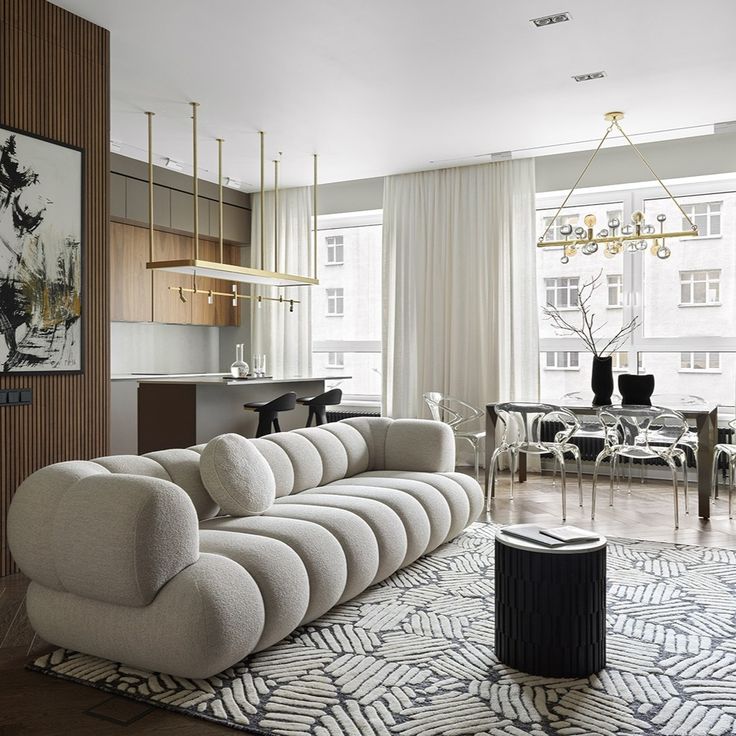 a living room filled with furniture and a chandelier hanging over the top of it