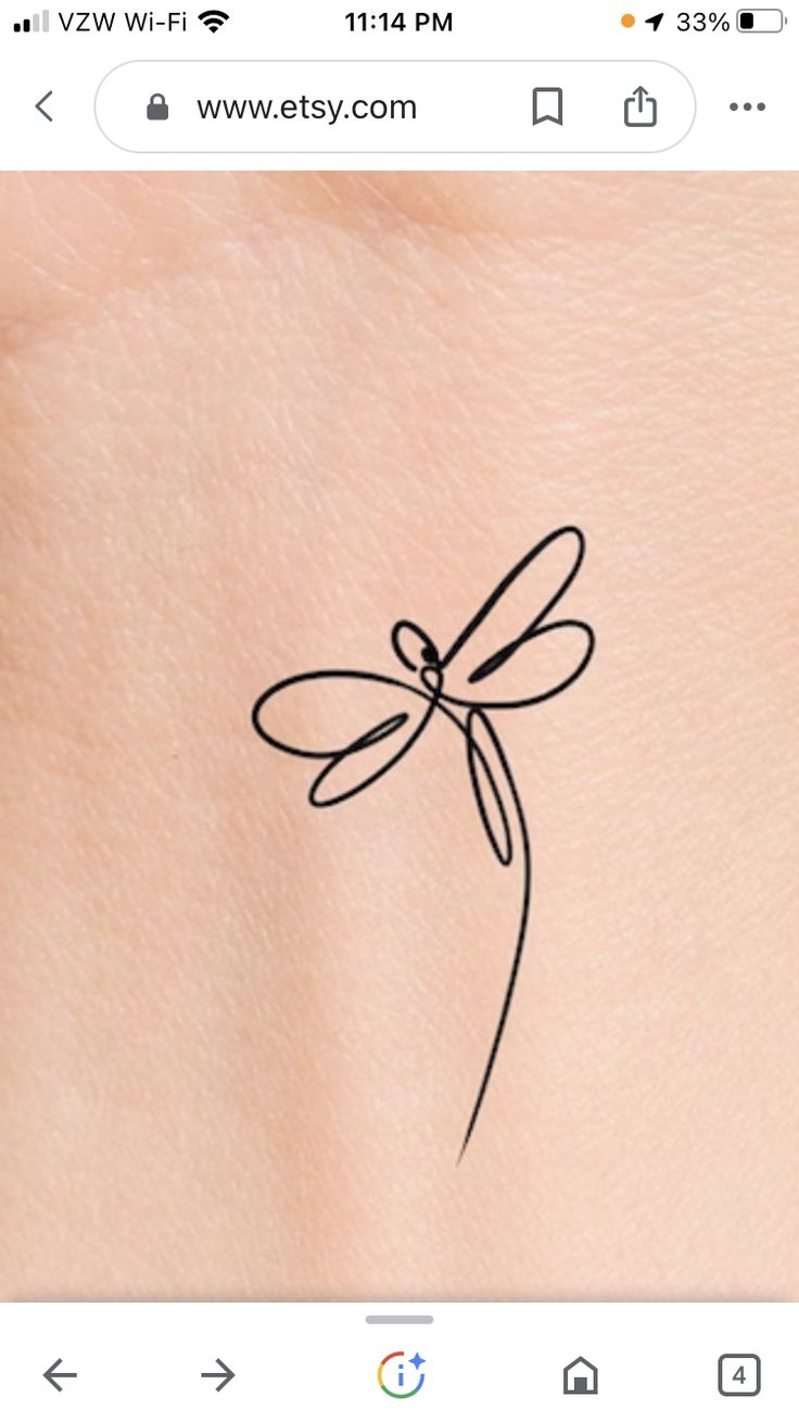 the back of a woman's stomach with a small tattoo dragonfly on it