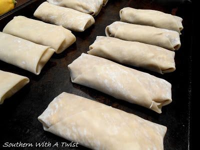 some dumplings are lined up on a baking sheet and ready to go into the oven