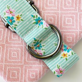 a pink and blue flowered fabric with a metal ring on it