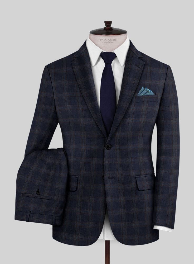 Exude confidence, charm, and lasting sophistication with our Reda Vidla Dark Blue Checks Wool Suit. Crafted from pure wool and adorned with a subtle light brown plaid pattern over the dark blue color, it elevates the ensemble, creating a captivating blend of hues and textures. This suit not only exudes impeccable style but also cocoons you in warmth and luxury all day long. Whether you're the best man at a wedding or attending a meeting, this suit is the perfect choice.  Look Includes   Reda Vid Navy Checkered Suit, Tailored Plaid Three-piece Suit For Formal Occasions, Classic Tailored Plaid Three-piece Suit, Plaid Suits For Semi-formal Occasions, Classic Plaid Three-piece Business Suit, Plaid Three-piece Suit With Notch Lapel For Formal Occasions, Tailored Plaid Three-piece Suit For Work, Semi-formal Plaid Suit, Plaid Semi-formal Suit