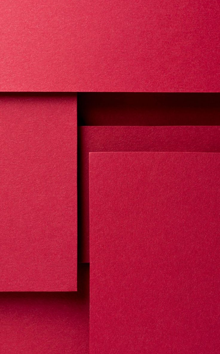 red paper folded up on top of each other with one corner cut out to show the bottom