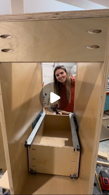 a woman standing inside of a wooden box