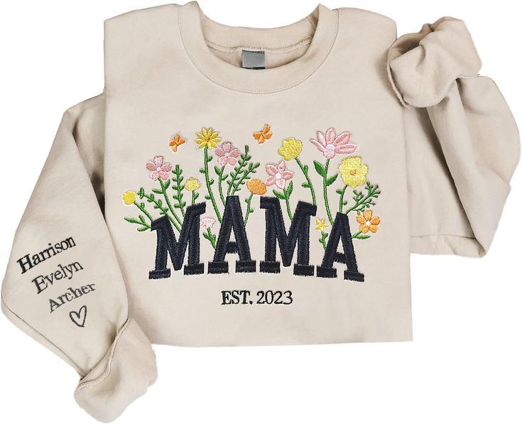 a white sweatshirt with the word mama printed on it and flowers in the front, along with an embroidered name