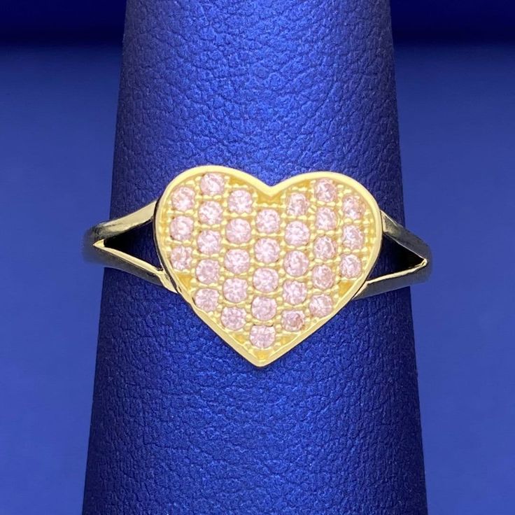 This heart ring is a beautiful piece of jewelry, crafted with a gorgeous heart shape, pink cubic zirconia stones and solid 10k yellow gold. A meaningful and luxurious symbol of love, make a special statement with this stunning ring! Metal: 10k Gold Stone: Cubic Zirconia Type: Ring Size: 7.5 We size up to two sizes free of charge. Please contact us for pricing on resizing more than two sizes. We need 2-3 business days to resize this ring. We do not accept returns on resized and/or altered rings. Pink 14k Gold Heart Ring For Promise, Pink 14k Gold Heart Promise Ring, Pink Heart Ring In Cubic Zirconia, Fine Jewelry Style, Yellow Gold Cubic Zirconia Heart Ring, Pink 14k Stamped Promise Ring, Pink Cubic Zirconia Heart Ring Fine Jewelry, Pink 14k Gold Heart Ring Gift, Anniversary Pink 14k Gold Heart Ring, Pink Cubic Zirconia Heart Ring For Anniversary