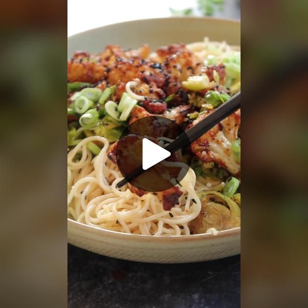 a bowl filled with noodles and meat on top of a table