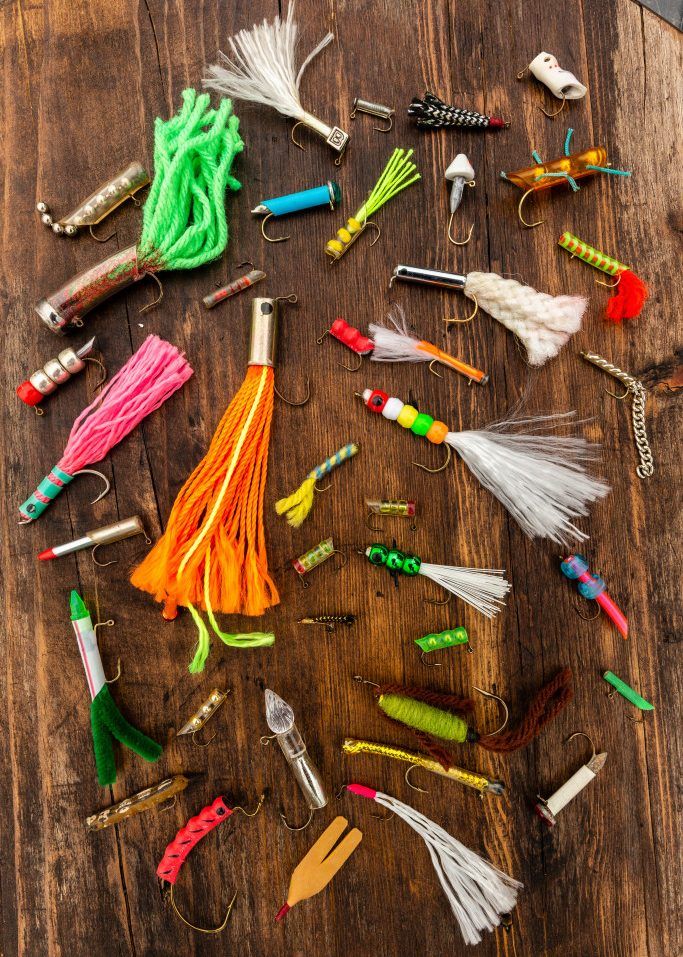 many different types of fishing lures on a wooden table