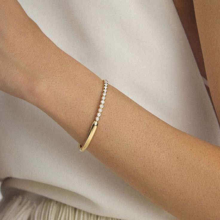 Our first bangle bracelet ever created, we imagined the Unico bracelet with the glamour of celebration in mind. This exceptional piece will be your go-to for those spotlight moments when you need some extra shine. Timeless White Gold Cuff Bracelet For Everyday Luxury, Elegant Yellow Gold Bangle With Diamond Accents, Elegant Yellow Gold Diamond Bracelet With Accents, Elegant Diamond Yellow Gold Bracelet, Elegant Gold Chain Bracelet With Diamond Accents, Everyday Luxury Flexible Diamond Bracelet, Elegant Yellow Gold Diamond Bracelet For Anniversary, Elegant Yellow Gold Bangle For Formal Occasions, Elegant Yellow Gold Diamond Bracelet