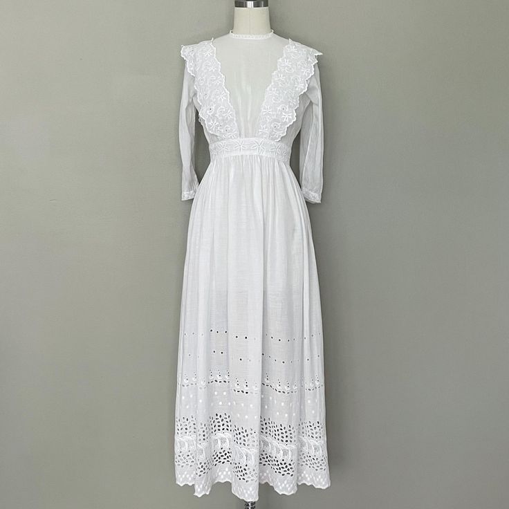 Semi sheer white cotton tea dress, embellished with eyelet and small daisy buttons.  -1910-1918 *Jewel neckline with lace edge  *Eyelet shoulder ruffles *Below elbow sleeves with lace edge *Eyelet waistband *Lightly gathered bodice *A line skirt, with wide eyelet edge *Back closes with tiny daisy mother of pearl buttons and two hooks at the waist There is a patch on the skirt center front, that was put there in the 1900s. It could be covered with some lace, embroidery, or a bow if it bothers you. It isn't very obvious when worn.   No label -------- --There are NO RETURNS on this dress.  ALWAYS READ ABOUT THE "CONDITION" SEE BELOW ⬇️ Thanks! --------- Wearable with care ---------- MEASUREMENTS in inches: Armpit to armpit 32 Shoulder to shoulder 14 Waist 23 (yours should be 22 or less) Hip O Fitted Victorian Cotton Dress With Lace Collar, Spring Victorian Cotton Dress With Lace Trim, Vintage Cotton Dress With Lace Cuffs, Long Sleeve Cotton Victorian Dress With Lace Trim, Edwardian Tea Dress, Edwardian Insertion Lace Dress, Eyelet Lace Dress, Jewel Neckline, Shirtwaist Dress