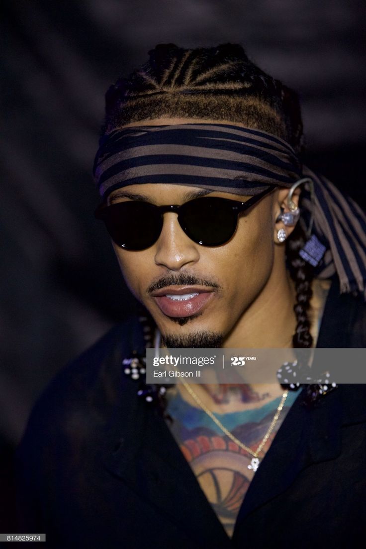 a man with dreadlocks wearing sunglasses and a bandana