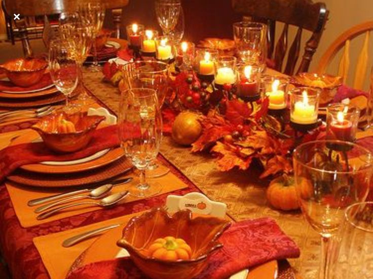 a table set for thanksgiving dinner with candles