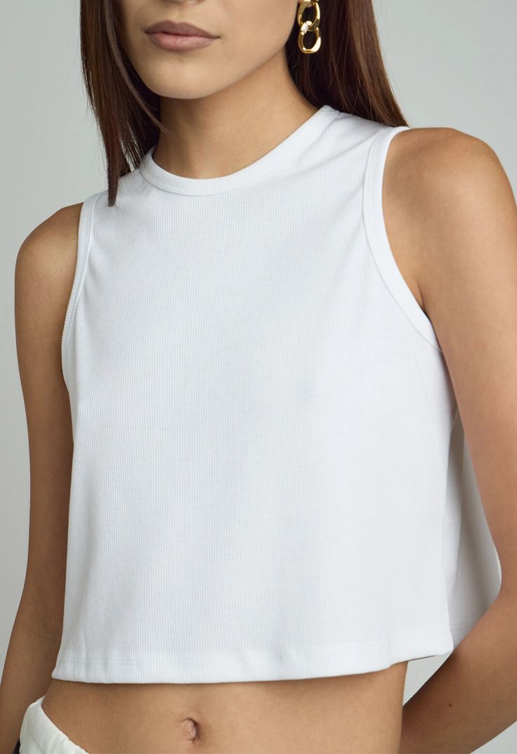 Ribbed Cropped Tank in White #contemporary #luxury #fashion #outfit #womensfashion #outfits #summer #tops #elevated #wardrobe #ootd #ootn #summeressentials #dallasfashion #designers #boutiques #shopping #clothing #casual #everydaystyle #nightout #date #outfit #resortwear #comfortable #leisurewear #couture #tailored #womensclothing #corporatebusinesswear #workwear #stylist #beach #thenkcstore #nicolekwon #koreanfashion #streetwear #streetstyle Basic Ribbed Sleeveless Top, Basic Sleeveless Ribbed Top, Chic White Ribbed Tank Top, Solid Sleeveless Crop Top For Layering, White Stretch Cotton Tank Top, Everyday White Ribbed Tank Top, White Seamless Sleeveless Crop Top, Stretch White Crop Top Vest, White Stretch Crop Top