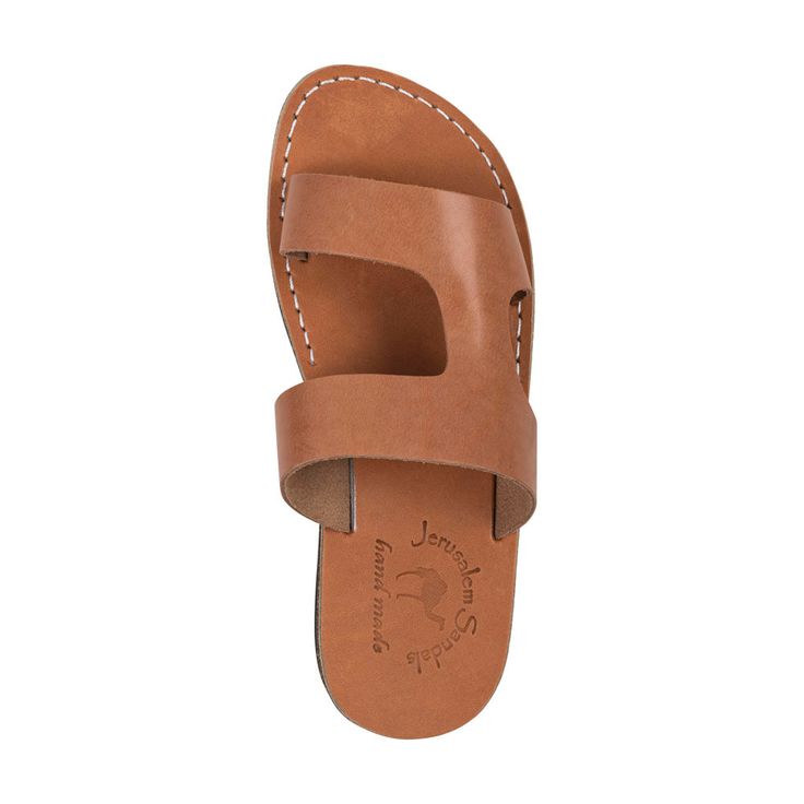 Meet 'June'—the epitome of effortless chic for the contemporary woman. This sandal is a fusion of simple elegance and practical design, ideal for those who appreciate subtlety with a touch of class. 'June' is crafted from soft, tan leather, ensuring both comfort and longevity. Its broad, asymmetrical straps offer a modern aesthetic while providing a secure fit that’s perfect for day-long wear. Whether paired with a breezy summer dress or your go-to jeans, the 'June' sandal is versatile enough to complement any outfit. With its sleek profile and comfortable sole, it’s the perfect staple for any fashion-forward wardrobe. Vegetable-tanned natural leather Leather sole molds to your feet Comfortable polyurethane outsole Durable textured grip sole Light and flexible Hand-Crafted in East Jerusale Classic Open Toe Flip Flops For Everyday, Classic Everyday Flip Flops With Single Toe Strap, Classic Beach Sandals, Classic Flip Flops For Everyday Spring Use, Classic Toe Loop Sandals For Summer, Classic Summer Toe Loop Sandals, Classic Adjustable Sandals For Beach, Classic Everyday Flip Flops For Spring, Classic Adjustable Beach Sandals