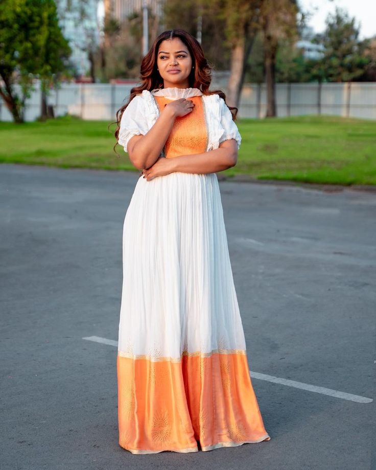 Description Bask in the warmth of simplicity with our Orange Habesha Kemis, a harmonious blend of tradition and modernity. Handwoven with care, each dress exudes an understated charm that captivates the senses. The vibrant orange hue adds a pop of color to your wardrobe while paying homage to Ethiopian heritage. With clean lines and minimalistic design, this dress celebrates the beauty of simplicity. Elevate your style effortlessly with the timeless allure of Habesha dress, a reflection of cultural richness and refined taste. Material Cotton Menen Thread Estimated delivery : 2 weeks to 3 weeks Delivered to your door 14days return policy Free shipping to North America (The US & Canada), EU & UK, UAE & Qatar Contact WhatsApp +1(304)-306-2784Email: contact@ethiopian.store White Short Sleeve Festive Dress, Traditional Short Sleeve Yoke Dresses, Traditional Short Sleeve Dress With Yoke, Habesha Dress Modern, Habesha Dress, Ethiopian Dress, Habesha Kemis, Dress Modern, Wedding Art