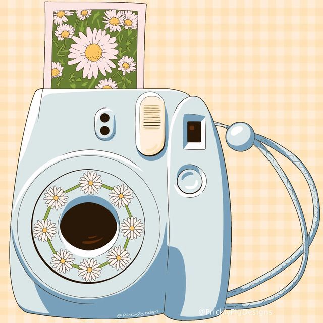 a blue camera sitting on top of a table next to a flowered wallpaper