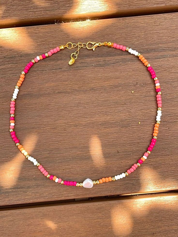 This vibrant seed bead necklace is a juicy slice of tropical heaven! This piece is a colorful celebration of summer's sweetness featuring tones of pink and orange. This necklace will transport you to a tropical paradise where the sun shines bright and the papaya's are always ripe. The perfect accessory that adds a pop of color to any outfit, and will give you beachy tropical vibes all summer long :) Cute Necklaces To Make With Beads, Cute Beaded Necklace Ideas, Beachy Seed Bead Necklace, Beachy Jewelry Necklaces, Glass Seed Bead Necklace Ideas, Seed Bead Necklace Ideas Summer, Cute Necklaces Beads, Beachy Beaded Necklace, Summer Seed Bead Necklace