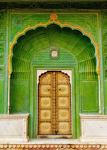 an ornate green building with gold doors