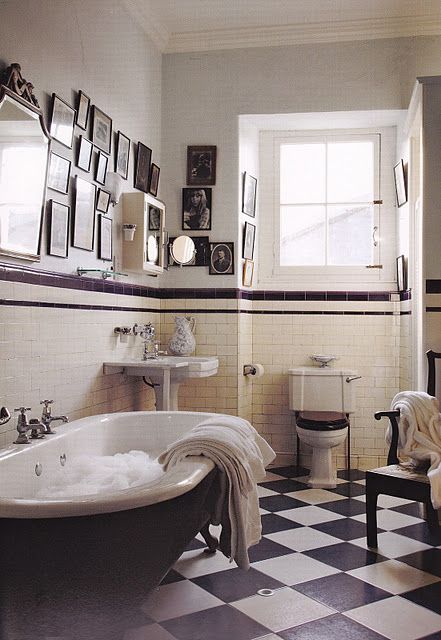 a bath room with a claw foot tub and a checkerboard floored floor