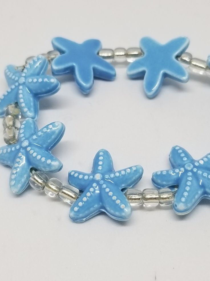 Stretch for the stars. A pastel blue bracelet of star shaped beads. Fun to wear anytime. A wonderful reminder of a day at the beach. Casual Star Jewelry For Summer, Summer Light Blue Beaded Bracelets As Gift, Light Blue Beaded Bracelets For Summer Gift, Light Blue Beaded Bracelets As Summer Gift, Casual Summer Star Shaped Jewelry, Summer Gift Light Blue Beaded Bracelets, Blue Star Jewelry For Vacation, Casual Star-shaped Summer Jewelry, Starfish Beaded Bracelets For Beach