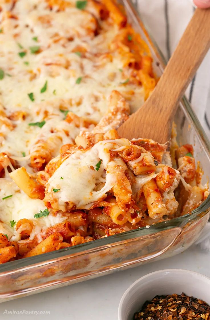 a casserole dish filled with pasta and cheese, topped with parmesan