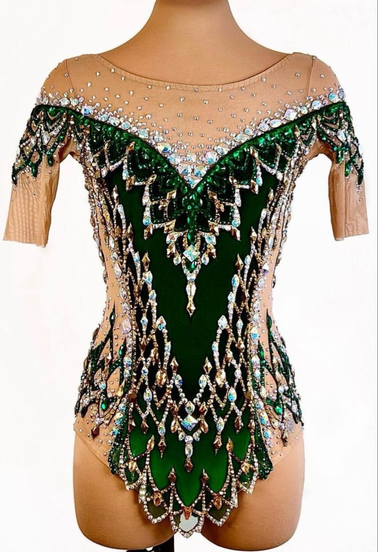 a woman wearing a green and white leotard with sequins on it