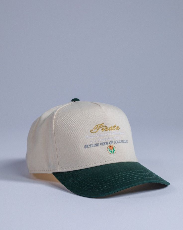 Pirate Skyline View Hat Size: Adjustable Snapback Cap Color: Cream/Green | Green Front Design Side PW Design Embroidery Stitch Count: 6,823 Embroidery Color: Gold, White, Grey, Orange, Red, Green, Cream Hats For Men Caps, Caps Design Ideas, Green Baseball Hat, Streetwear Hats, Hat Cream, Country Hats, Fits Aesthetic, Embroidery Stitch, Skyline View