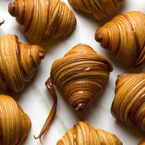 many pieces of food that are on a white plate and one is cut in half to look like croissants