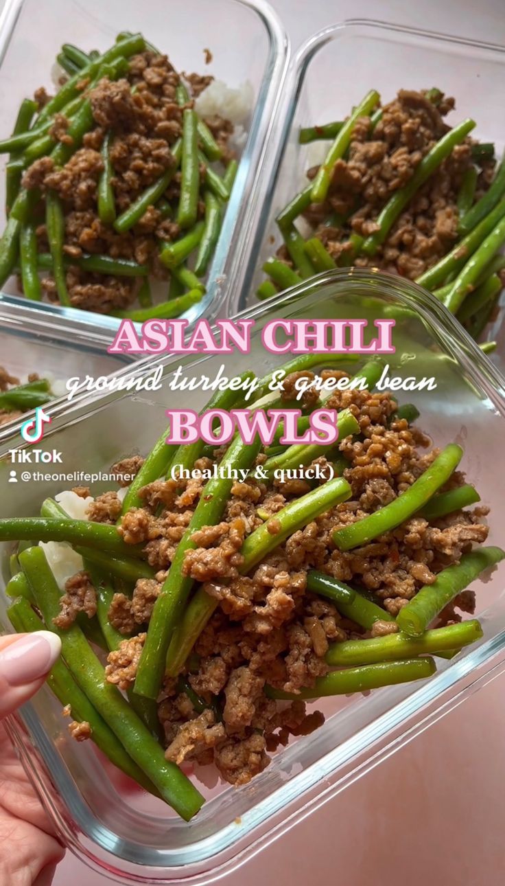 three plastic containers filled with green beans covered in ground meat and onions, sitting on a table