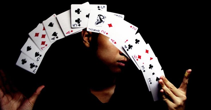 a woman holding four playing cards in front of her face