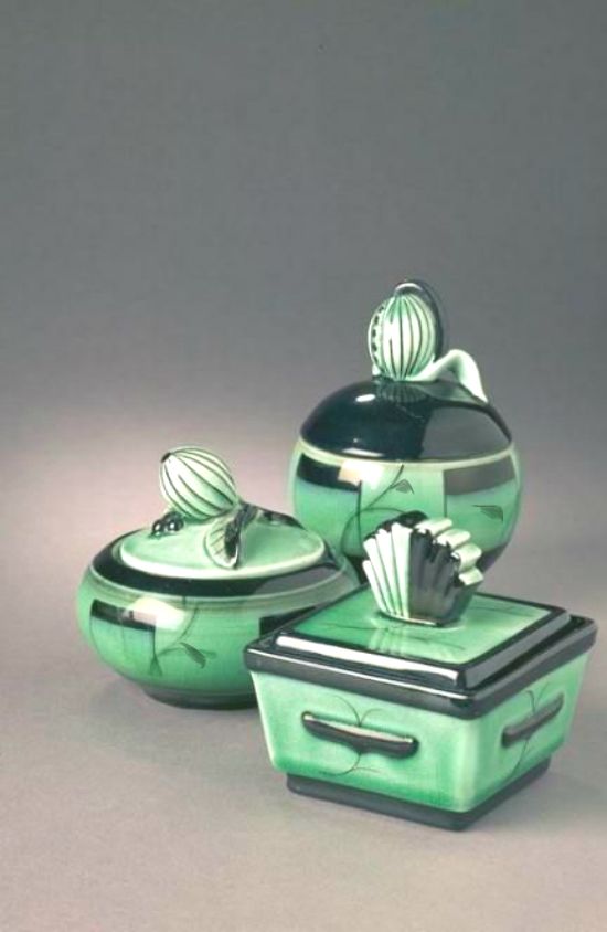 three pieces of green pottery sitting next to each other on a gray surface with black accents