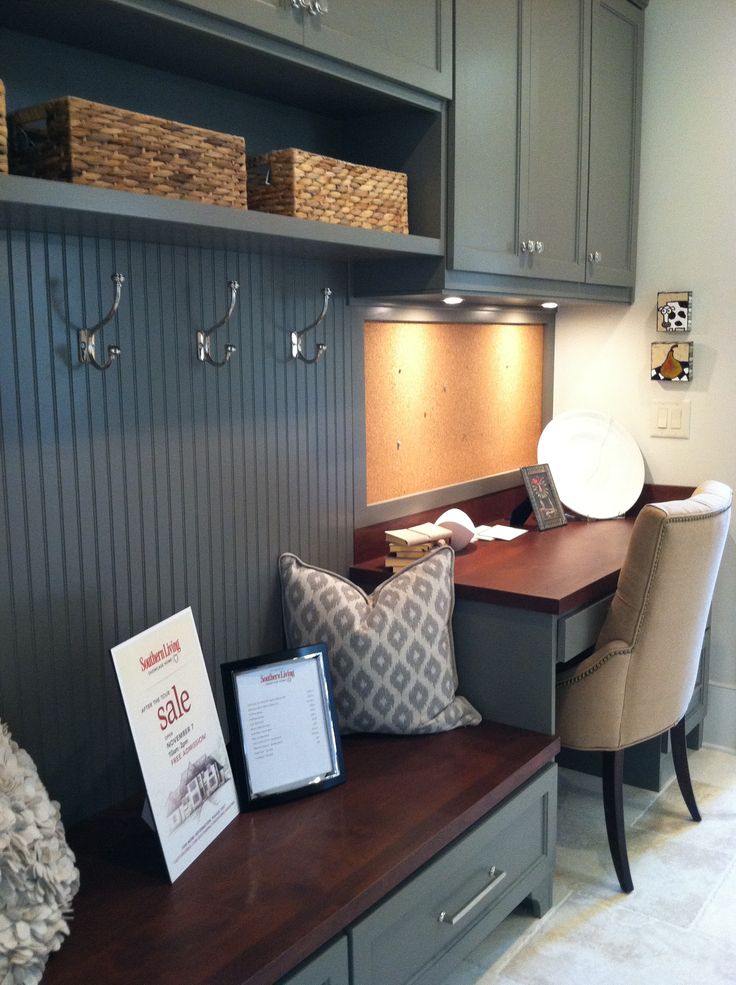 a home office with gray cabinets and wooden desk