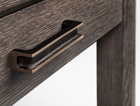 a close up of a drawer handle on a wooden desk top with metal handles and wood grained finish