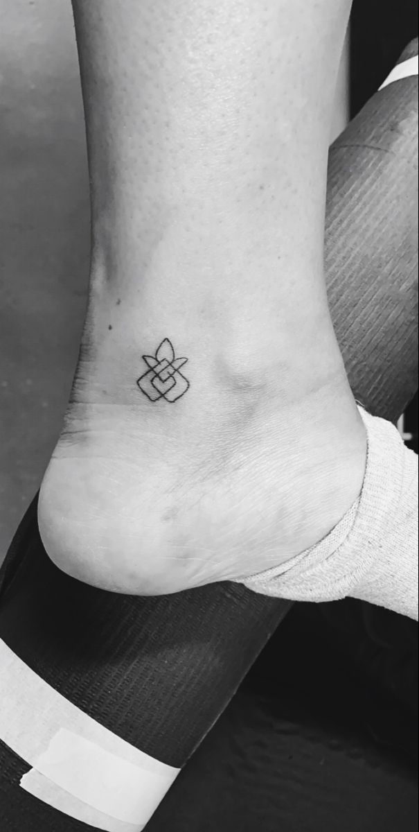 a black and white photo of a person's foot with a small tattoo on it