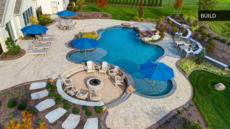 an aerial view of a pool with patio furniture and umbrellas