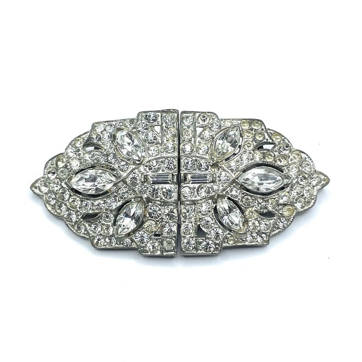 Click LEARN MORE ABOUT THIS ITEM below for item specifics and policies. Item: This is a classic Art Deco brooch / clip combo made circa 1940. In the early 1930s the Coro jewelry company patented their Duette. It is a clever invention that allows a brooch to be separated and used as a pair of dress or shoe clips. This piece is not signed with the manufacturers name. It's in good condition with no missing stones but shows some patina consistent with age. Click Add To Cart to Buy this, click the Heart button to Favorite, and check our other listings for lots more antique and vintage jewelry! Signature: Pat. 2044225 Measurements: 2 1/2" w x 1 1/4" Condition: 7 - Good, patina and wear consistent with age Shipping: U.S. shipping is $5.00 for USPS First Class Mail with Tracking. Faster Insured Pr Vintage Rhinestone Brooches For Vintage Events, Vintage Rhinestone Brooches For Evening, Vintage Evening Brooches With Rhinestones, Retro Wedding Brooches With Rhinestones, Antique Rhinestone Brooches For Vintage Events, Antique Rhinestones Brooch For Vintage Events, Clever Inventions, Coro Jewelry, Art Deco Brooch