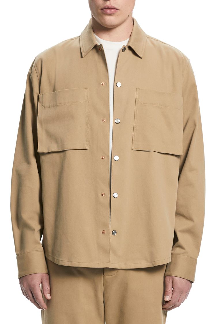 Roomy and relaxed, this overshirt made of sanded cotton twill features hand-brushed metallic snaps and a touch of stretch to keep you moving comfortably. 29" length (size medium) Front snap closure Spread collar Long sleeves with two-snap cuffs Chest bellows pockets 98% cotton, 2% elastane Dry clean Imported Beige Relaxed Fit Button-up Shacket, Oversized Cotton Shirt With Snap Buttons, Beige Relaxed Fit Shacket With Button Closure, Khaki Shirt With Snap Buttons For Fall, Utility Long Sleeve Tops With Snap Buttons, Fall Khaki Shirt With Snap Buttons, Beige Collared Shacket With Snap Buttons, Khaki Tops With Snap Buttons For Everyday, Everyday Khaki Tops With Snap Buttons