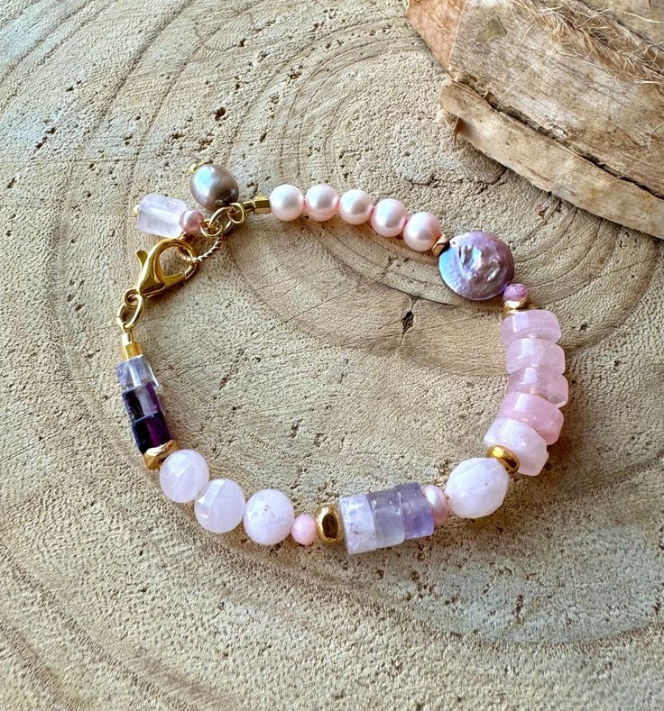 Pretty in pink is the perfect description for this Sundance style multi gemstone stacking bracelet. Wear it with your jeans and boots for a casual vibe and/or with your little black dress for a dressier look. It can easily go solo on your wrist as well as being part of a stack of bracelets that you love. Comprising the bracelet are the following: 1 - 5 natural pink potato freshwater pearls (approx 5x7mm) 2 - A single gorgeous deep mauve freshwater pearl coin (approx 12mm) 3 - 5 yummy pink quartz heishi beads 4 - One soft pink faceted puffed quartz coin nestled between (approx 9mm) 5 - 3 amethyst shaded heishi beads           (approx 7x5mm) 6 - 3 faceted rose quartz faceted puff              coins (approx 7mm) 7 - 3 shaded fluorite cubes (approx 6mm           x6mm x6mm) 8 - Various gold spa Pink Gemstone Beads Bracelets For Healing, Pink Gemstone Beaded Bracelets For Jewelry Making, Pink Gemstone Bracelets For Jewelry Making, Pink Beaded Bracelets With Natural Stones, Adjustable Pink Beaded Bracelets With Natural Stones, Pink Bracelets With Natural Stones And Round Beads, Pink Gemstone Beaded Bracelets For Healing, Pink Gemstone Beads Bracelets As Gift, Pink Adjustable Beaded Bracelets For Healing