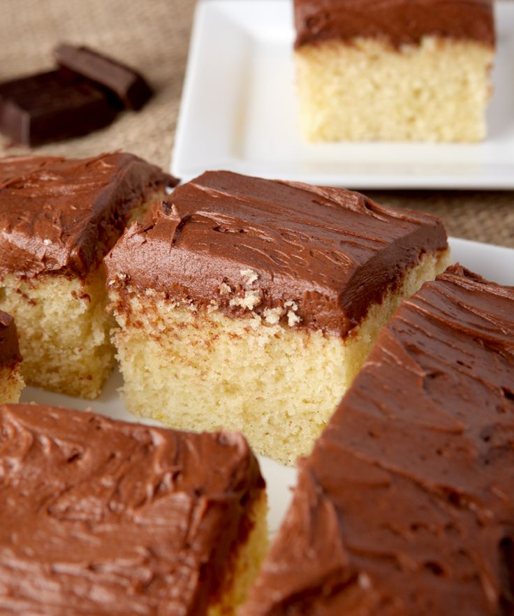 two pieces of cake with chocolate frosting sitting on a plate next to another piece of cake