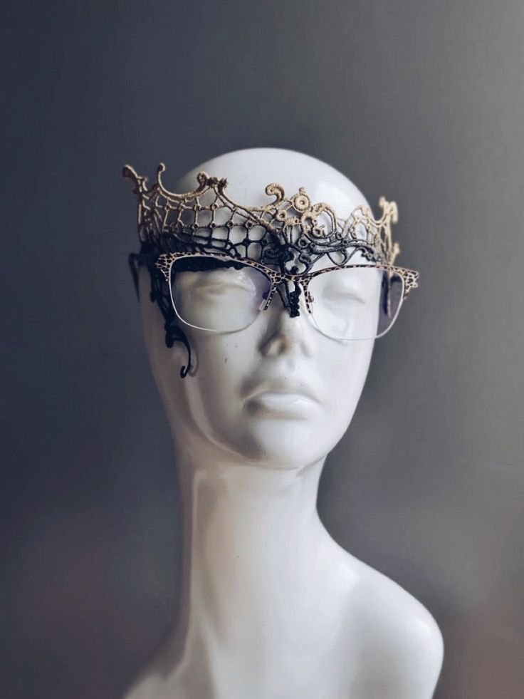 Embrace the elegance of Gilded Noir, a black and gold lace mask tailored specifically for eyeglass wearers. This exquisite mask features intricate lacework that seamlessly integrates with eyeglasses, providing a perfect blend of style and practicality. Ideal for masquerade balls, costume events, or any occasion where you want to make a striking impression. Age Group/Gender - Adult Women Mask Color - Black Gold Size - One size fits all adults Mask Material - Lace Masculine Masquerade Mask, Elegant Halloween Masquerade Masks And Prosthetics, Elegant Eye Mask For Halloween, Elegant Halloween Eye Mask, Elegant Halloween Costume Eye Mask, Elegant Party Eye Mask, Elegant Eye Mask For Formal Masquerade, Gold Gothic Mask, Gold Adjustable Masquerade Mask