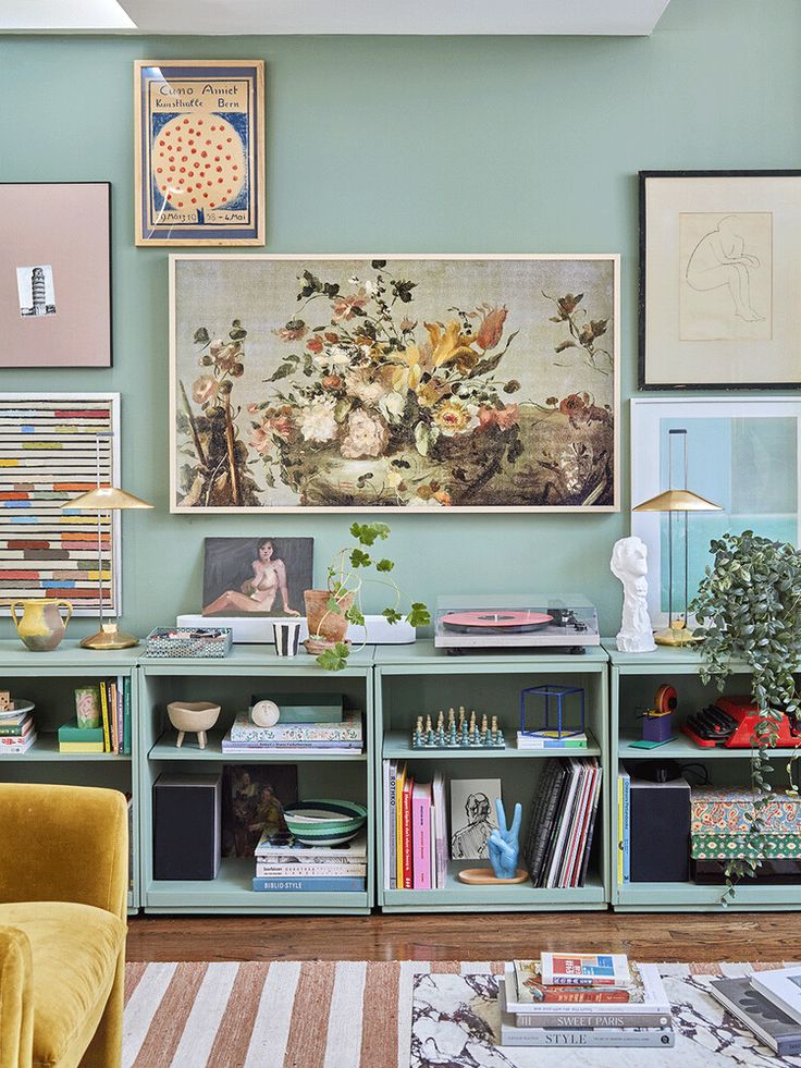 a living room filled with lots of furniture and pictures on the wall above it's bookshelf